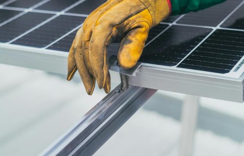 Gros plan sur la fixation d’un panneau solaire par un technicien