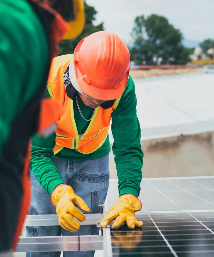 Technicien sur le toit en train d’installer des panneaux